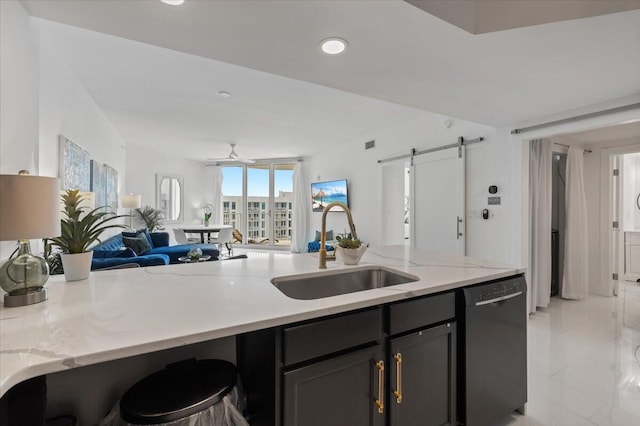 kitchen featuring black dishwasher, sink, light stone countertops, a barn door, and ceiling fan