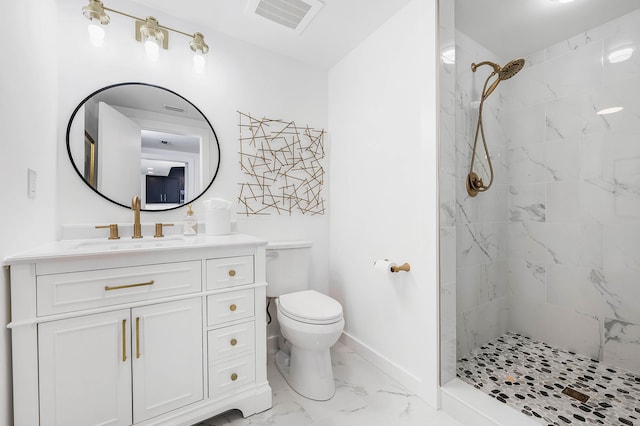 bathroom featuring vanity, tiled shower, and toilet