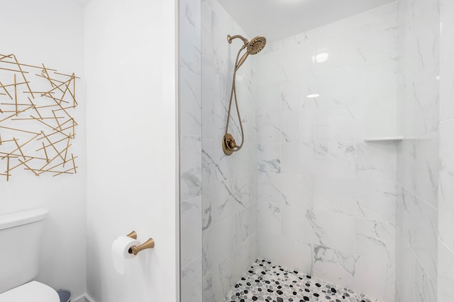 bathroom featuring tiled shower and toilet