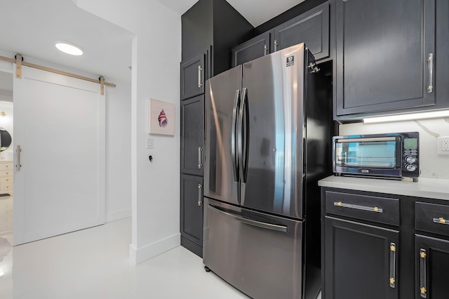 kitchen with a barn door and stainless steel fridge