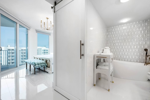 bathroom with a chandelier, tile patterned flooring, and a bathing tub