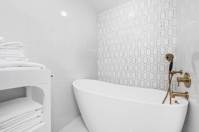 bathroom featuring tile walls and a washtub