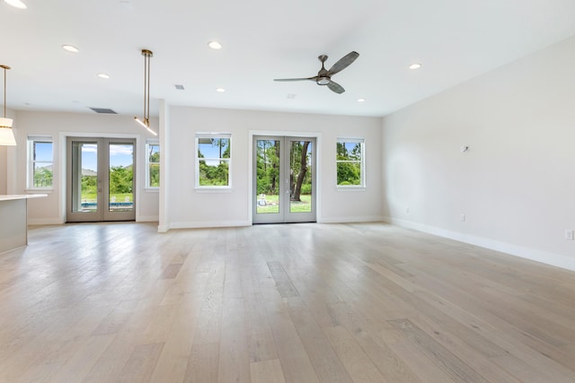 spare room with ceiling fan, light hardwood / wood-style flooring, french doors, and a wealth of natural light