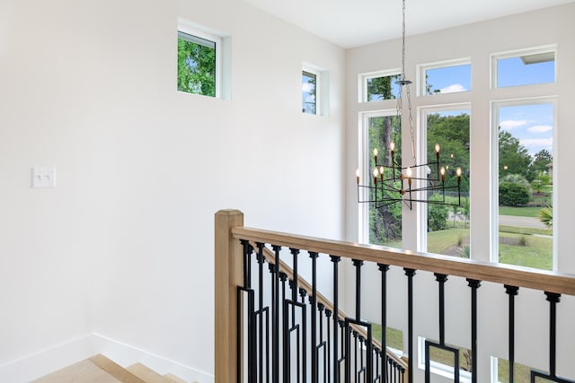 hallway featuring a chandelier and plenty of natural light