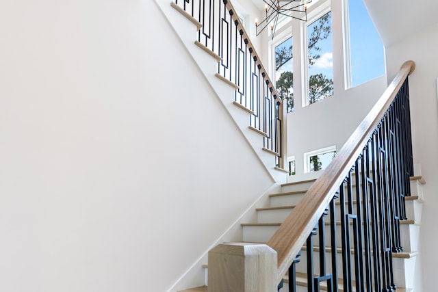 stairway with a notable chandelier