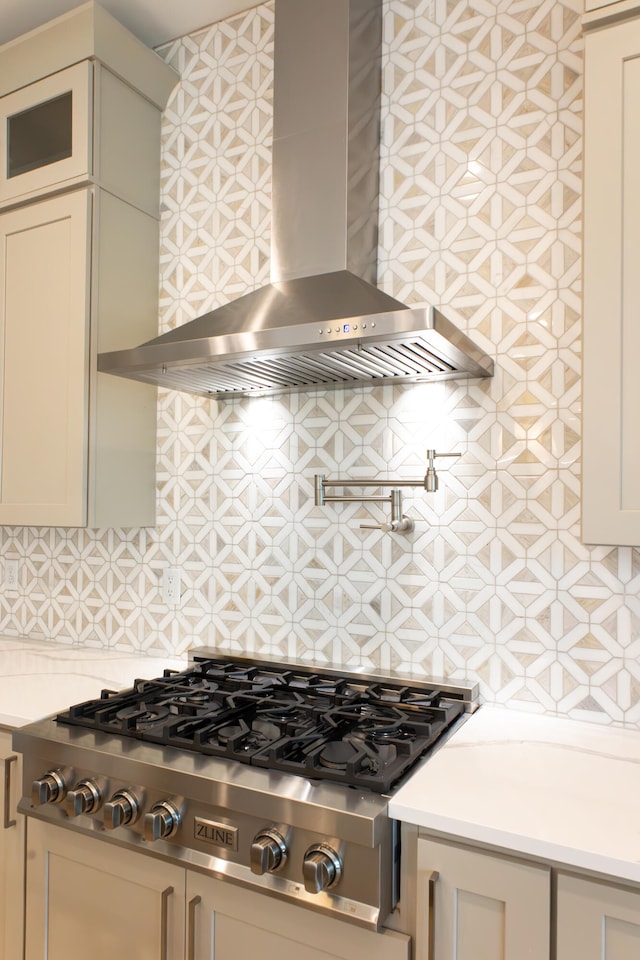 kitchen with stainless steel gas stovetop, tasteful backsplash, and wall chimney exhaust hood