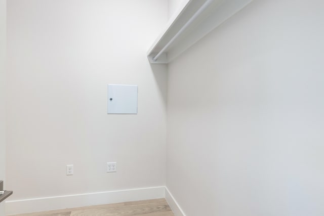 clothes washing area with light hardwood / wood-style flooring