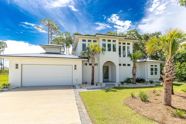 mediterranean / spanish-style home featuring a front lawn and a garage