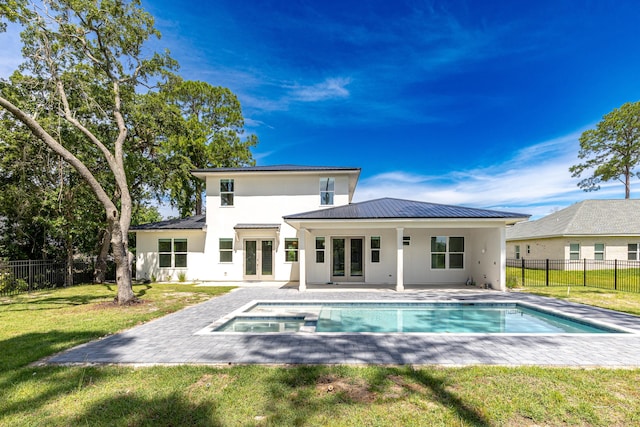 rear view of property with french doors, a fenced in pool, a patio area, and a yard