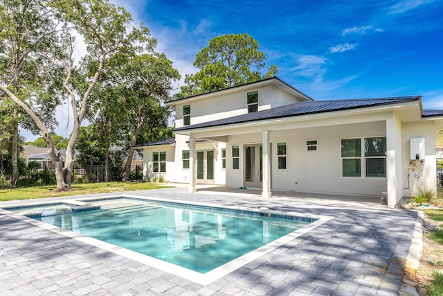 back of property with a patio and a fenced in pool