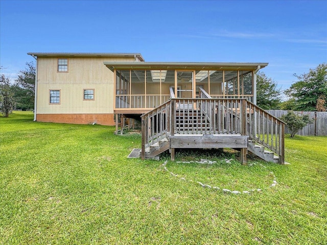 rear view of house featuring a lawn and a sunroom