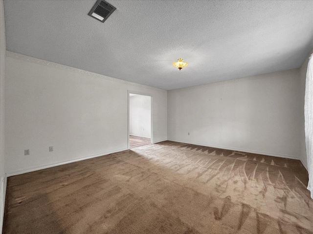 carpeted spare room featuring a textured ceiling