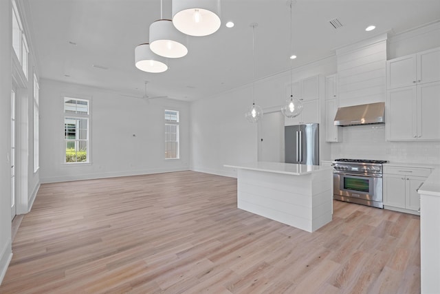 kitchen featuring decorative backsplash, stainless steel appliances, extractor fan, white cabinetry, and hanging light fixtures