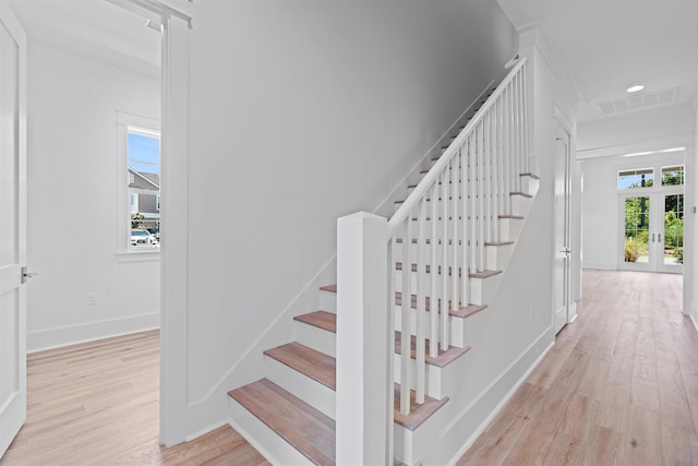 stairway with wood-type flooring and french doors