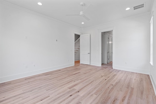 unfurnished room with ceiling fan, light wood-type flooring, and crown molding