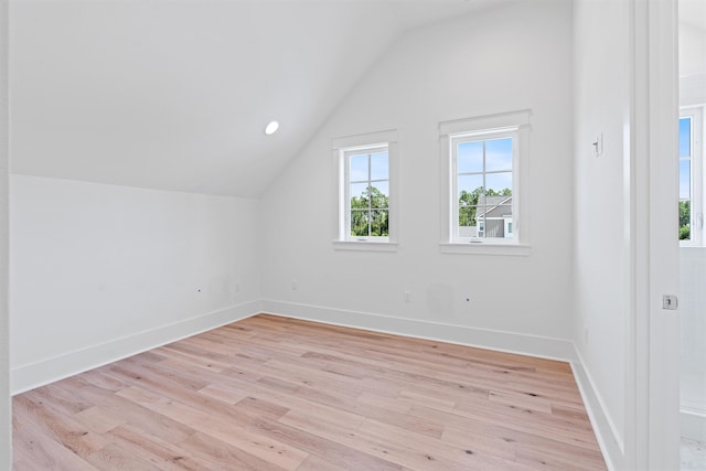 additional living space featuring light hardwood / wood-style flooring and vaulted ceiling