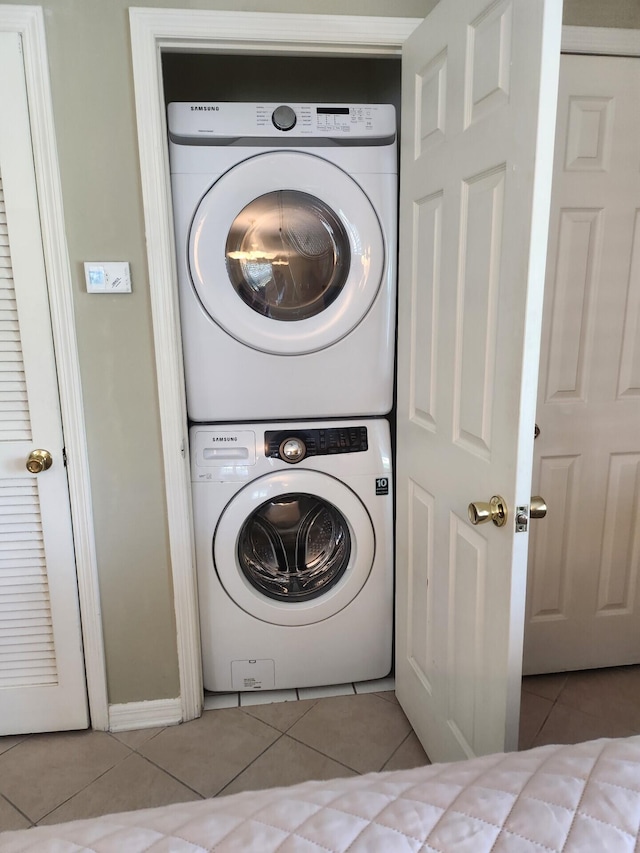 washroom featuring tile flooring and stacked washer / drying machine