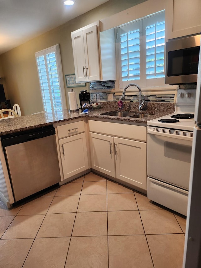 kitchen with plenty of natural light, stainless steel appliances, sink, and light tile floors