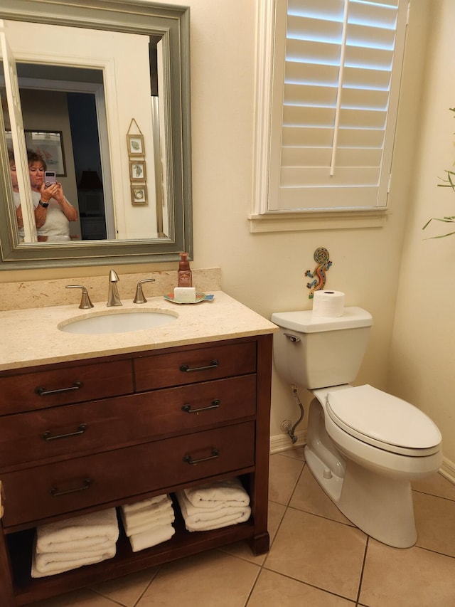 bathroom with vanity, toilet, and tile floors