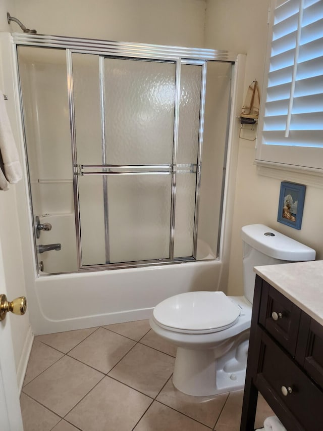 full bathroom with tile floors, combined bath / shower with glass door, toilet, and vanity