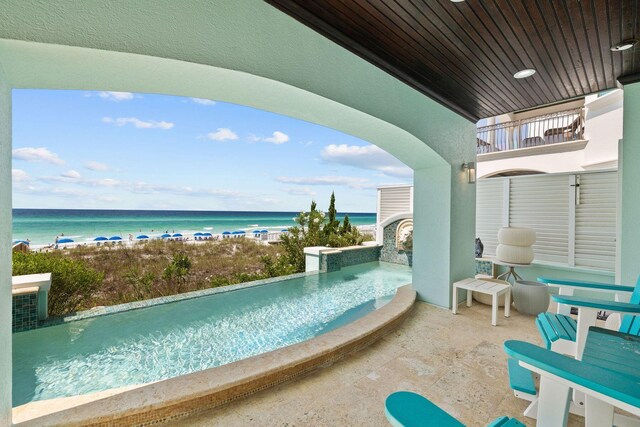 view of swimming pool featuring a jacuzzi and a water view