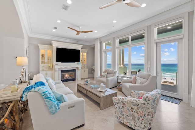 living room featuring visible vents, a high end fireplace, a ceiling fan, ornamental molding, and recessed lighting