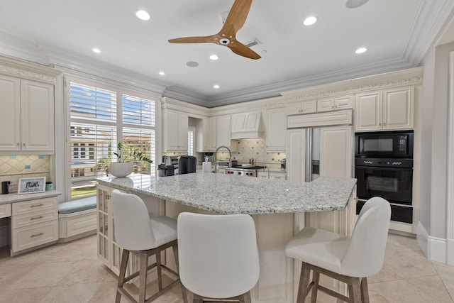 kitchen with ornamental molding, a breakfast bar area, premium range hood, and black appliances