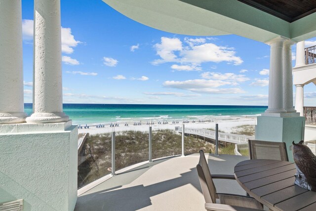 balcony featuring a water view and a beach view