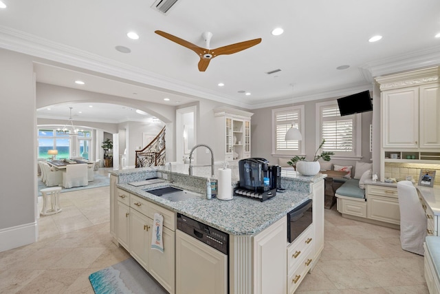 kitchen with arched walkways, a kitchen island with sink, a sink, plenty of natural light, and paneled dishwasher