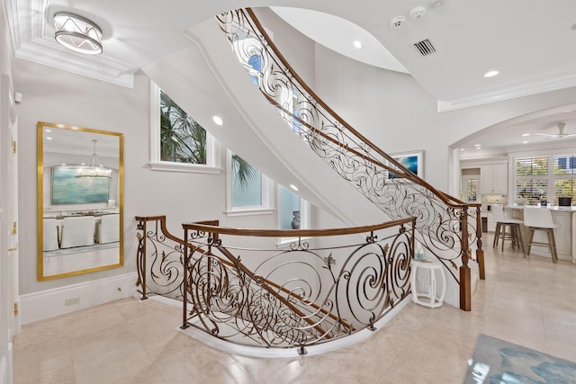 stairway with tile patterned flooring, ornamental molding, arched walkways, and recessed lighting