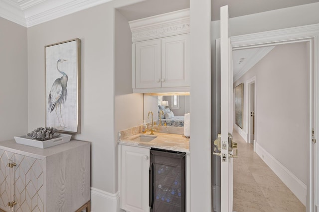 bar featuring beverage cooler, ornamental molding, a sink, and baseboards