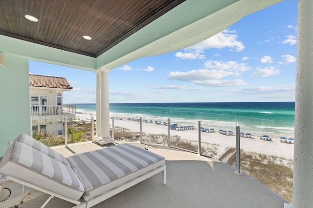 balcony featuring a view of the beach and a water view