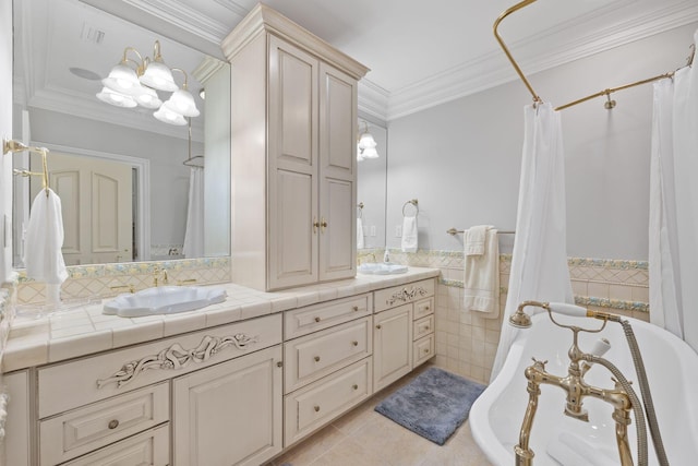 bathroom featuring crown molding, a freestanding tub, a sink, and tile patterned floors