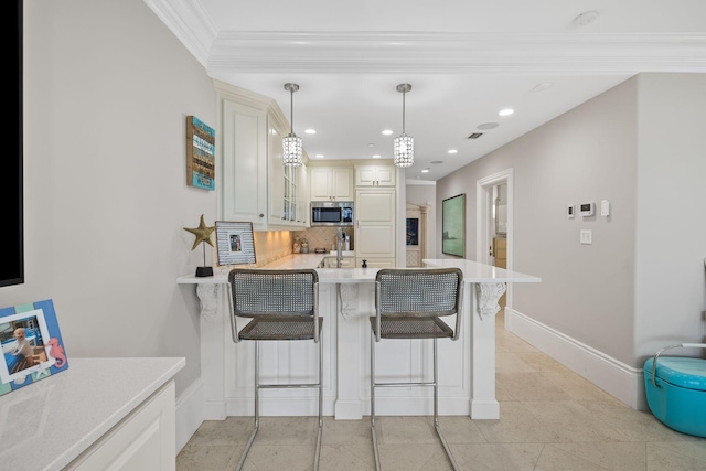 kitchen with a breakfast bar, light countertops, stainless steel microwave, backsplash, and glass insert cabinets