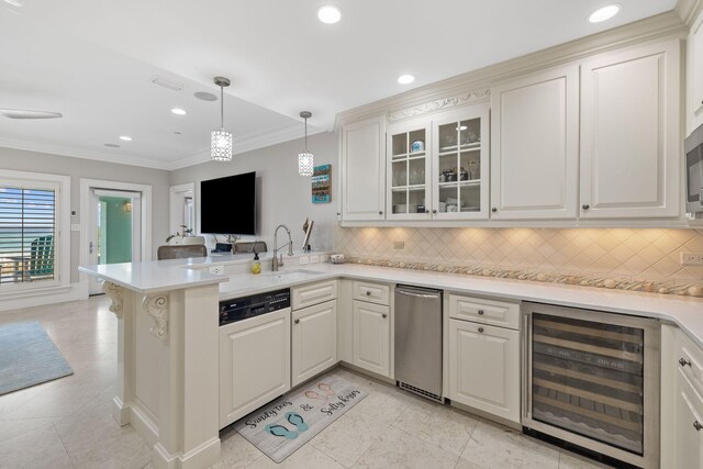 kitchen with paneled dishwasher, ornamental molding, a sink, beverage cooler, and a peninsula