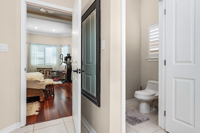 bathroom with tile flooring, ornamental molding, and toilet