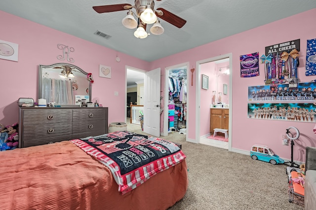 carpeted bedroom featuring a spacious closet, connected bathroom, a closet, and ceiling fan