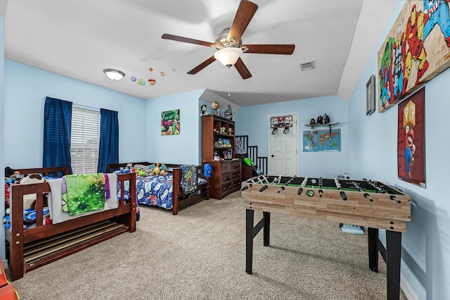 game room with carpet flooring, ceiling fan, and a textured ceiling