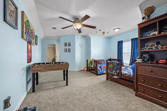 playroom with ceiling fan, a textured ceiling, and light colored carpet