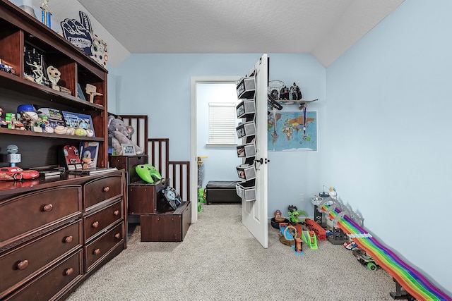 recreation room with a textured ceiling and light carpet