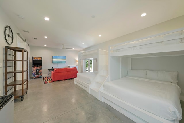 bedroom with a barn door and concrete floors