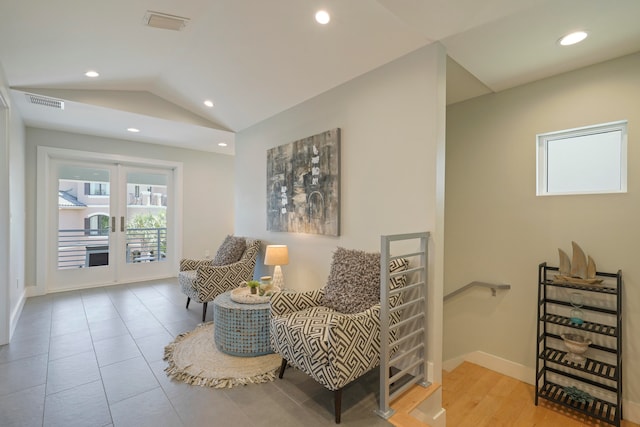 living area featuring vaulted ceiling and light tile flooring