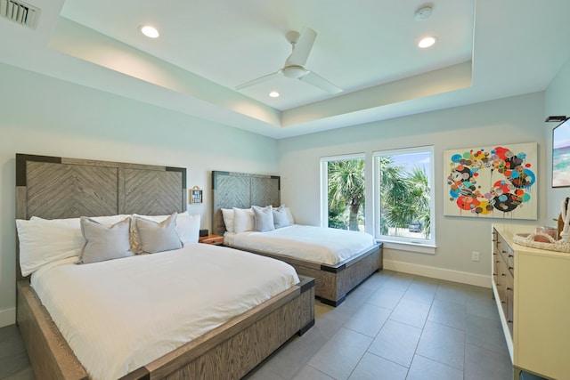 bedroom with tile flooring, ceiling fan, and a raised ceiling