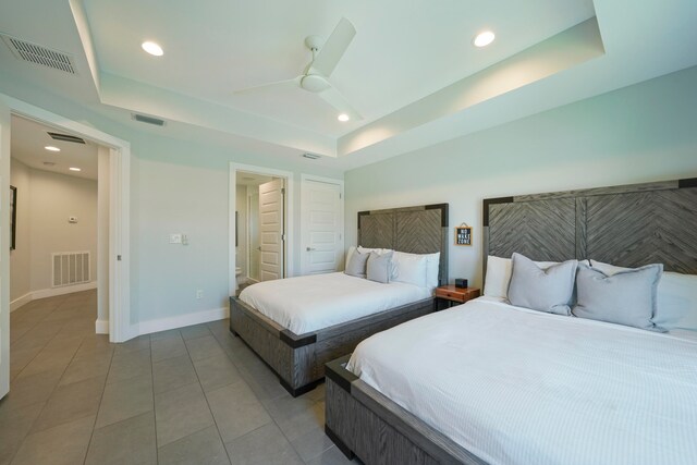 bedroom featuring tile floors, ceiling fan, and a raised ceiling