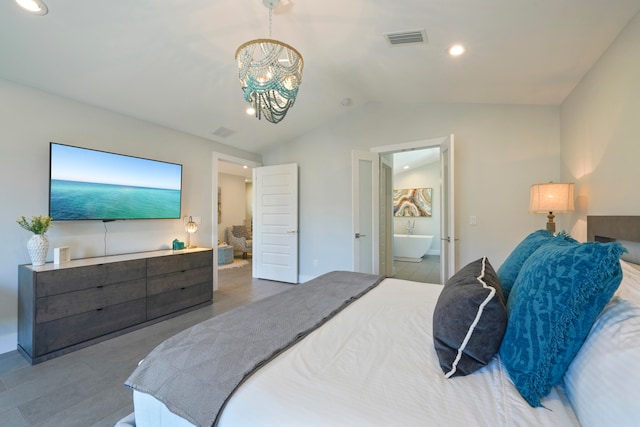 bedroom featuring an inviting chandelier, connected bathroom, and vaulted ceiling