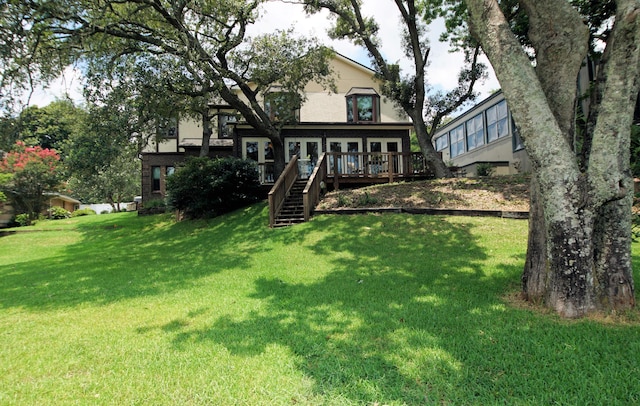 back of property featuring french doors, a yard, a wooden deck, and stairs