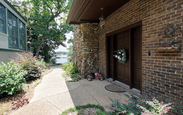 doorway to property featuring brick siding and a water view