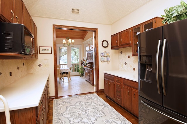 kitchen featuring tasteful backsplash, visible vents, fridge with ice dispenser, light countertops, and black microwave