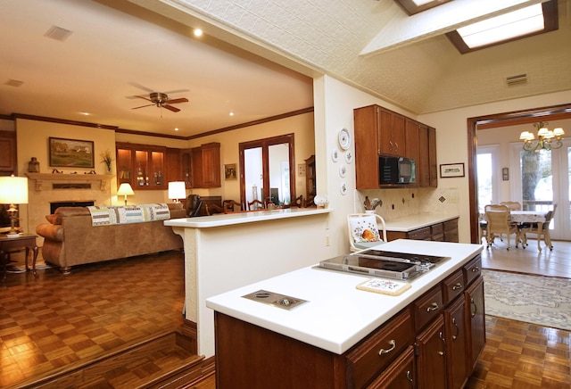 kitchen with black microwave, light countertops, visible vents, and open floor plan