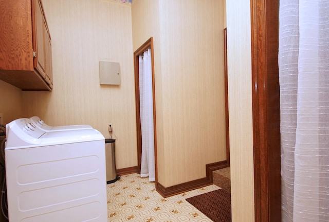 washroom with cabinet space, separate washer and dryer, baseboards, and wallpapered walls